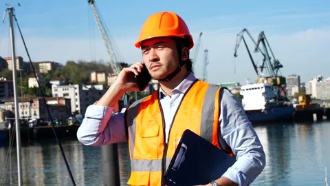 Cargo port worker coordinating operations with a smartphone Stock Footage 333731210