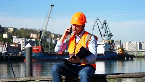 Cargo port worker talking on phone at the commercial dock Stock Footage 333731184