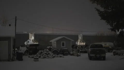 Cargo rain passes behind small town building covered in snow at night Stock Footage 225418521