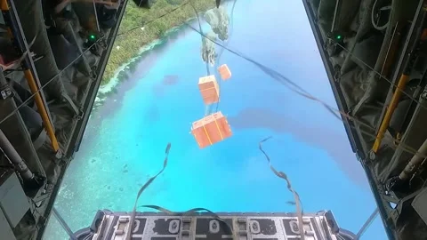 Cargo secured to parachute is dropped from C-130 Hercules into the Pacific Ocean Stockbeeldmateriaal 295990297