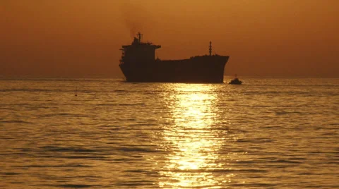 Cargo ship and pilot boat at sunset Stock Footage 30720030