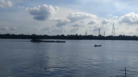 Cargo Ship and Small Boat Navigating Wide River Under Cloudy Sky Vidéo 340829916