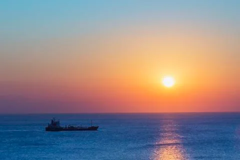 Cargo ship and sunrise over the Mediterranean sea. Stock Photos