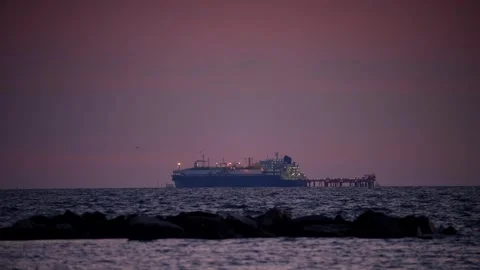 Cargo ship approaches the dock at sunset Stock Footage 345722659