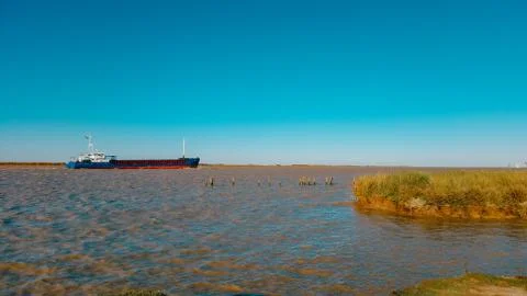 Cargo ship approaching the river. Cargo ship in the distance. freight transpo Stock Photos