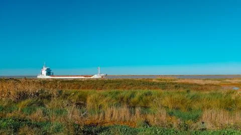 Cargo ship approaching the river. Cargo ship in the distance. freight transpo Stock Photos
