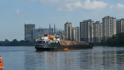 Cargo ship with a cargo of timber in the background of tall houses Stock Footage 113338958