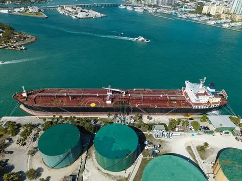 Cargo ship with container at fuel storage tank with petroleum in industrial area Fotos de archivo