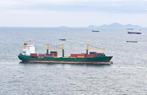 Cargo ship with containers sailing on the sea Stock Photos