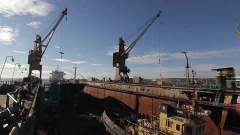 Cargo ship in dock, cranes load containers for maritime transport. Workers in Stock Footage 271673164