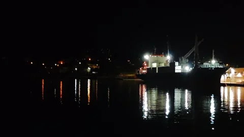 Cargo ship docked, lights reflect. Video stock 323655154