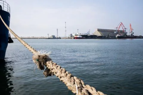 Cargo ship docked in port. Big rope close up Stock Photos