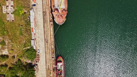 Cargo ship is docked at the port during the day near the water Stock Footage 338325030