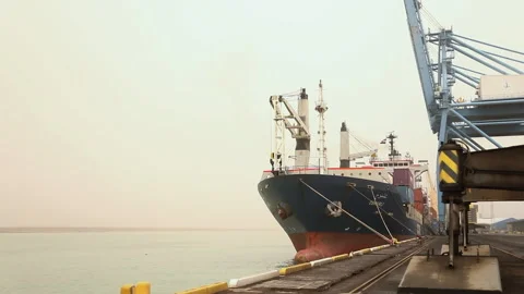 Cargo ship docked at port for loading operations at sunset Stock Footage 318198085