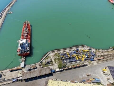 Cargo ship docked at port with loading equipment in the background Stock Photos