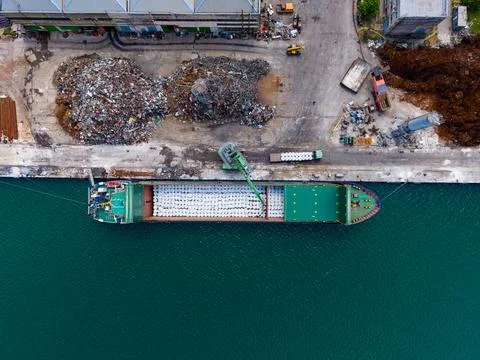 Cargo ship docked at port while unloading materials and machinery during da.. Fotos de archivo