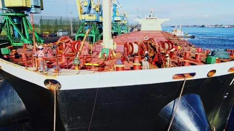 Cargo Ship Docking at Industrial Port - Crew Handles Mooring Lines on Foredeck Stock Footage 344078588