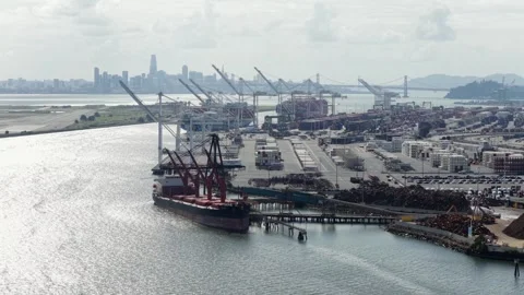 Cargo ship docks beneath towering gantry cranes at Port of Oakland, container Stock Footage 339985585