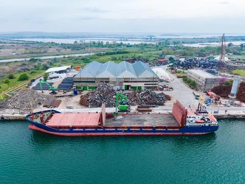 Cargo ship docks at a recycling facility in a coastal area for unloading sc.. Fotos de archivo