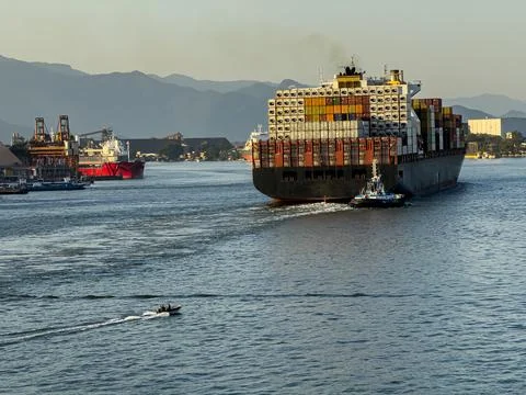 Cargo ship entering a city. Stock Photos