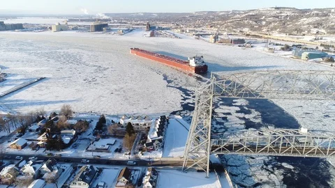Cargo Ship Entering the Duluth Harbor in Winter - Aerial View Stock Footage 99991169