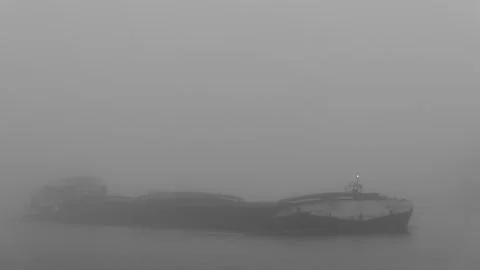 A cargo ship with front light in dense fog Stock Photos