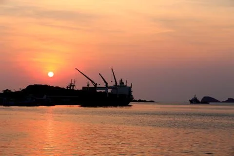 Cargo ship in the harbor at sunset Stock Photos