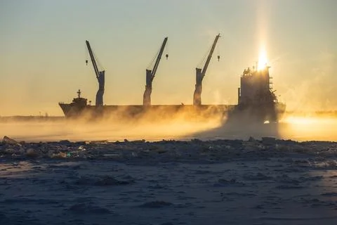 Cargo ship, ice classed bulk carrier in the ice and fog of a freezing river. Stock Photos