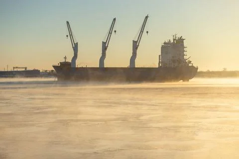 Cargo ship, ice classed bulk carrier in the ice and fog of a freezing river. Foto stock