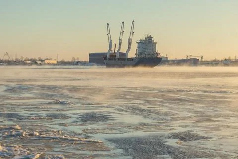 Cargo ship, ice classed bulk carrier in the ice and fog of a freezing river. Foto stock