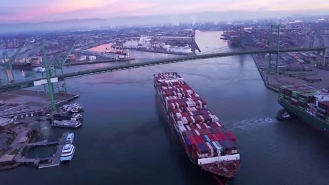Cargo ship loaded with containers moving under the bridge at harbor during dusk Video stock 83695401