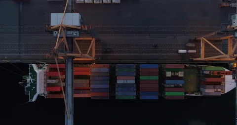 Cargo ship loading in container terminal port aerial top down view at night Stock Footage 135659981