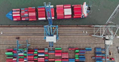Cargo ship loading containers at busy port terminal Stock Footage 330085133