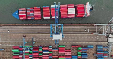 Cargo ship loading containers at busy port terminal Stock Photos