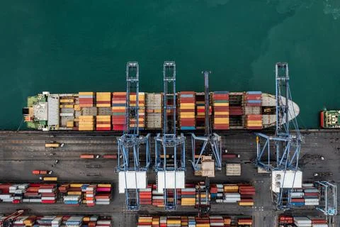 Cargo Ship Loading Containers At Industrial Shipping Port Overhead Shot Stock Photos