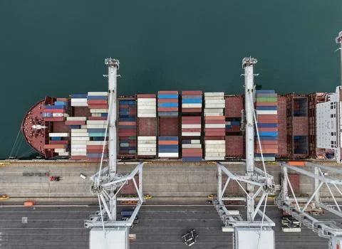 Cargo ship loading containers at port logistics terminal Stock Photos