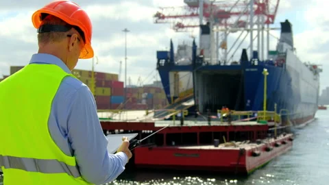 Cargo ship loading in dock manager communicates with team 스톡 동영상 167354652