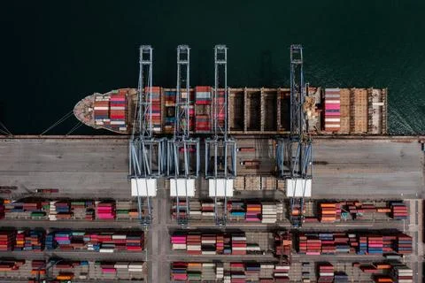 Cargo Ship Loading Freight Containers At Bustling Deep Water Harbor Termina.. 库存照片