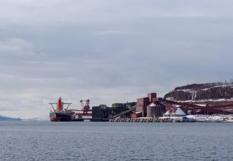 Cargo ship loading iron ore at the Port of Narvik in northern Norway on a win Stock Photos
