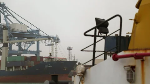 Cargo ship loading operations at port under cloudy skies Stock Footage 318200187