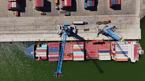 Cargo ship loading at port with cranes in action during daytime 動画素材 339018446