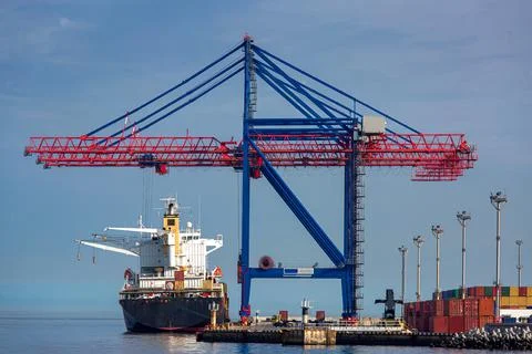 A cargo ship moored at the berth of the container ship yard. Stock Photos