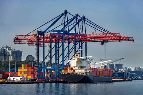 Cargo ship moored for loading at container yard. Stock Photos