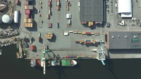 Cargo ship moored at port, loading &amp; unloading cargo containers, aerial view. Video stock 133309196