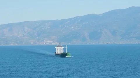 A cargo ship moves across the blue waters of the Pagasetic Gulf with the Stock Footage 346681275