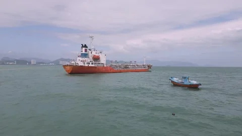 Cargo ship navigates calm waters near coastal city skyline Video stock 308246007