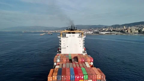 Cargo ship navigates through calm waters near city skyline on a clear day Stock Footage 288200136