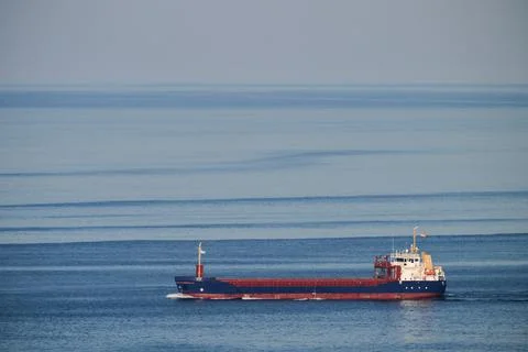 Cargo ship navigating blue ocean waters transporting freight Fotos de archivo