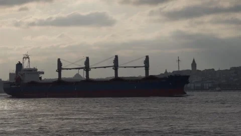 Cargo Ship Navigating in Bosphorus with City Skyline Stockbeeldmateriaal 333295497