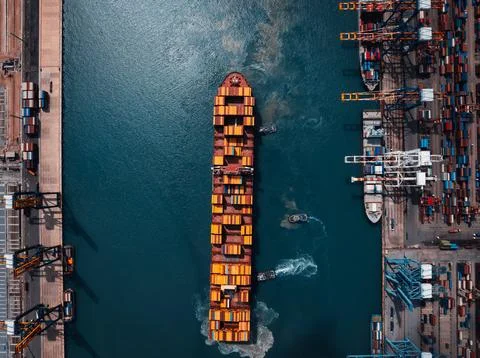 Cargo Ship Navigating Through Busy Port Terminal In Thailand Aerial View 库存照片